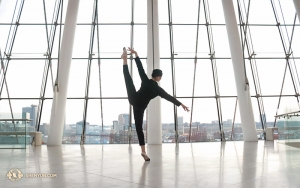 Dancer Helen Li enjoys an afternoon break in the lobby of the Kansas City Kauffman Center for the Performing Arts, relaxing while casually performing a páng tuǐ tǎng shēn (旁腿躺身), or “side leg with inclined body.” (Photo by dancer Diana Teng)